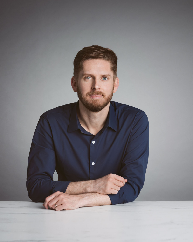 Drew Worden with a slight smile while sitting at a desk