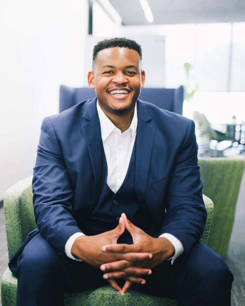 Kyle Lilly, smiling while sitting in an office lounge chair